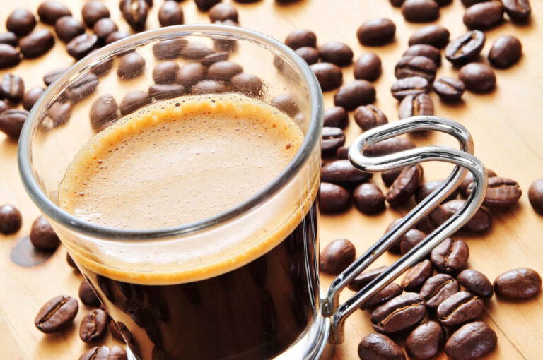 a cup of espresso and whole coffee beans - is espresso supposed to be bitter