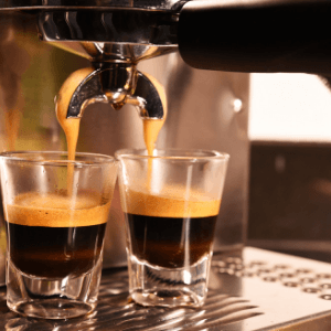 Espresso machine and two shot glasses.
