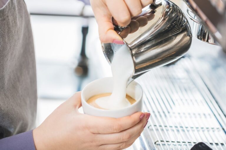 Frothy milk being poured into a cup of Cappuccino.