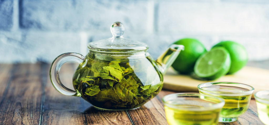 Green tea brewed in a glass pot.