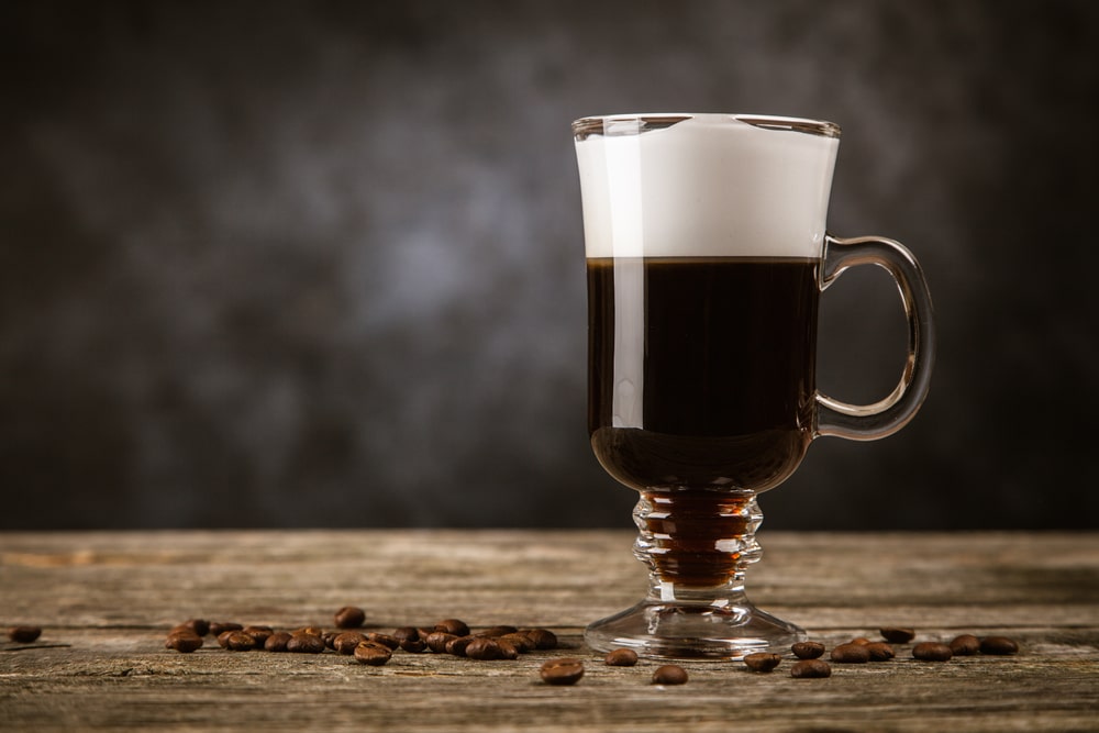 A glass mug on a table, with a cold brew coffee liqueur.