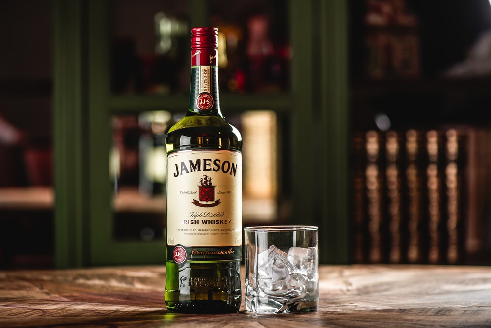 A bottle of whiskey sitting on top of a wooden table