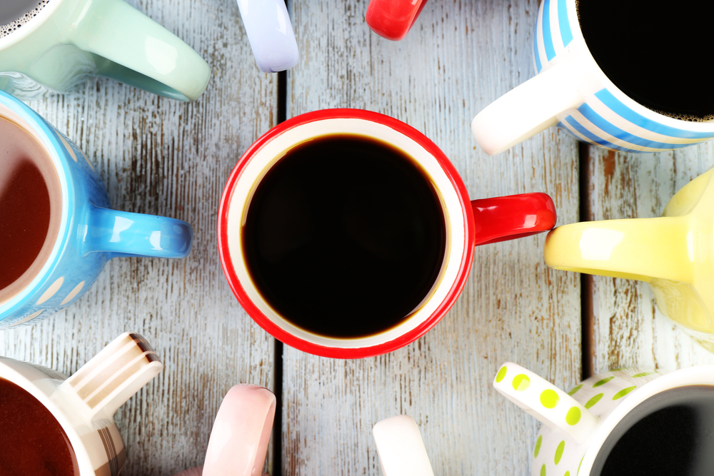 Many cups of coffee on wooden table