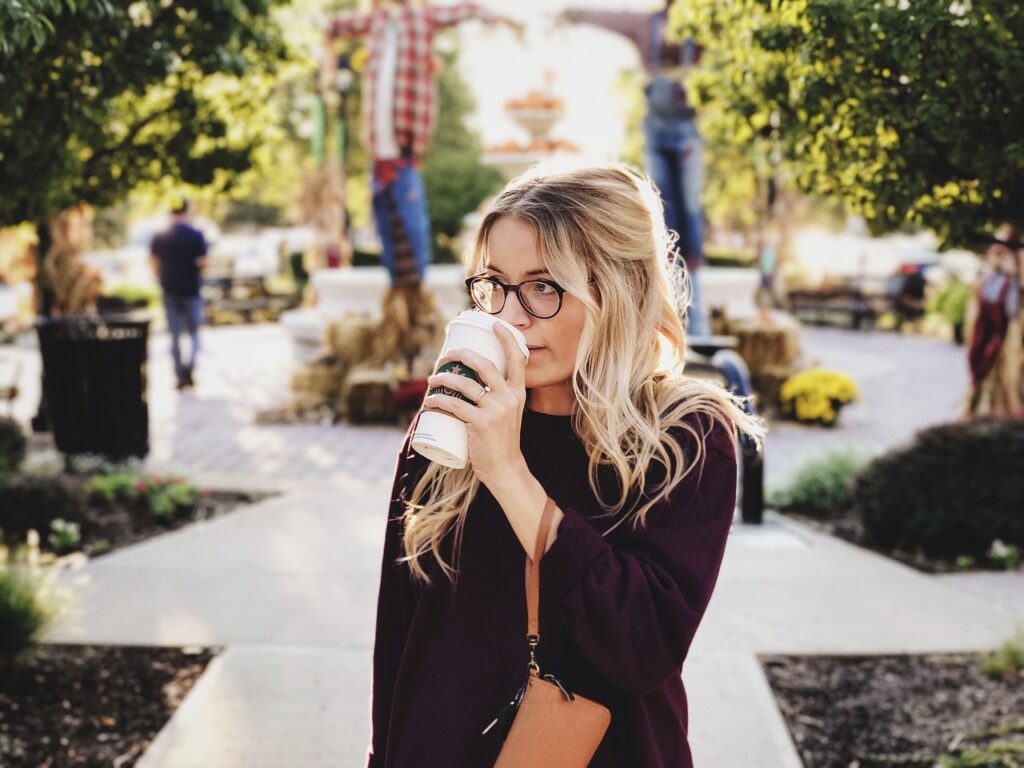 Woman drinking her take-out coffee in a park