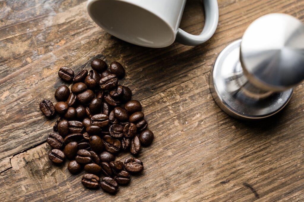 Coffee beans laid on top of a flat wooden surface