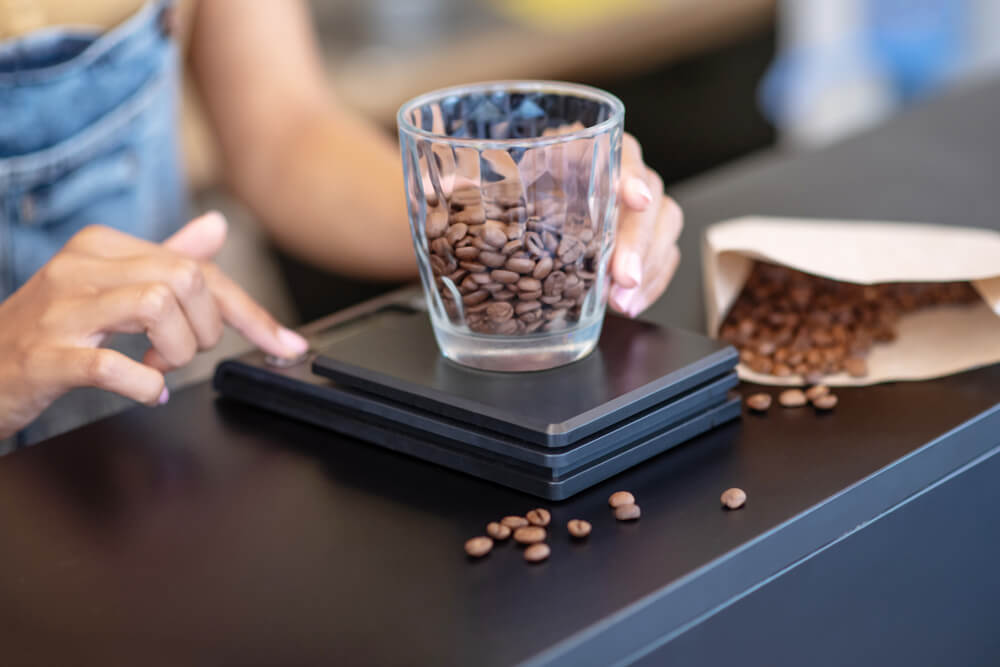 weighing whole beans of coffee