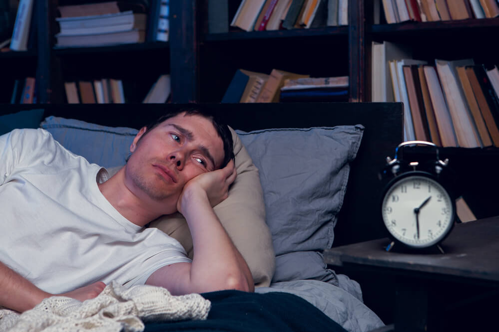 how long does coffee keep you awake - man laying in a couch looking troubled