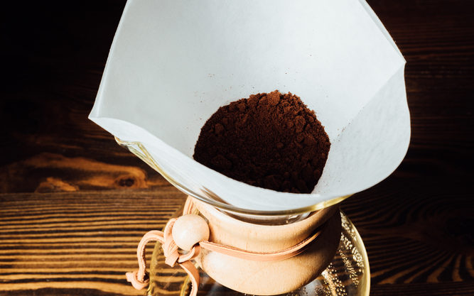 Top view of Chemex with white filter containing ground coffee.