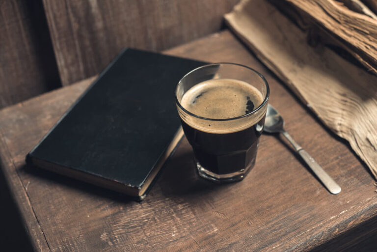old look of a coffee beside a journal notebook