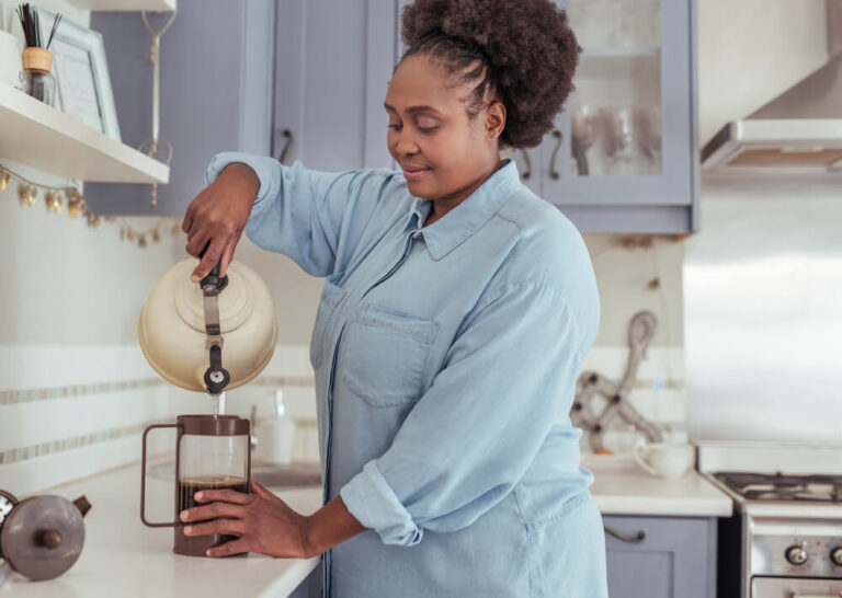 woman preparing French press coffee
