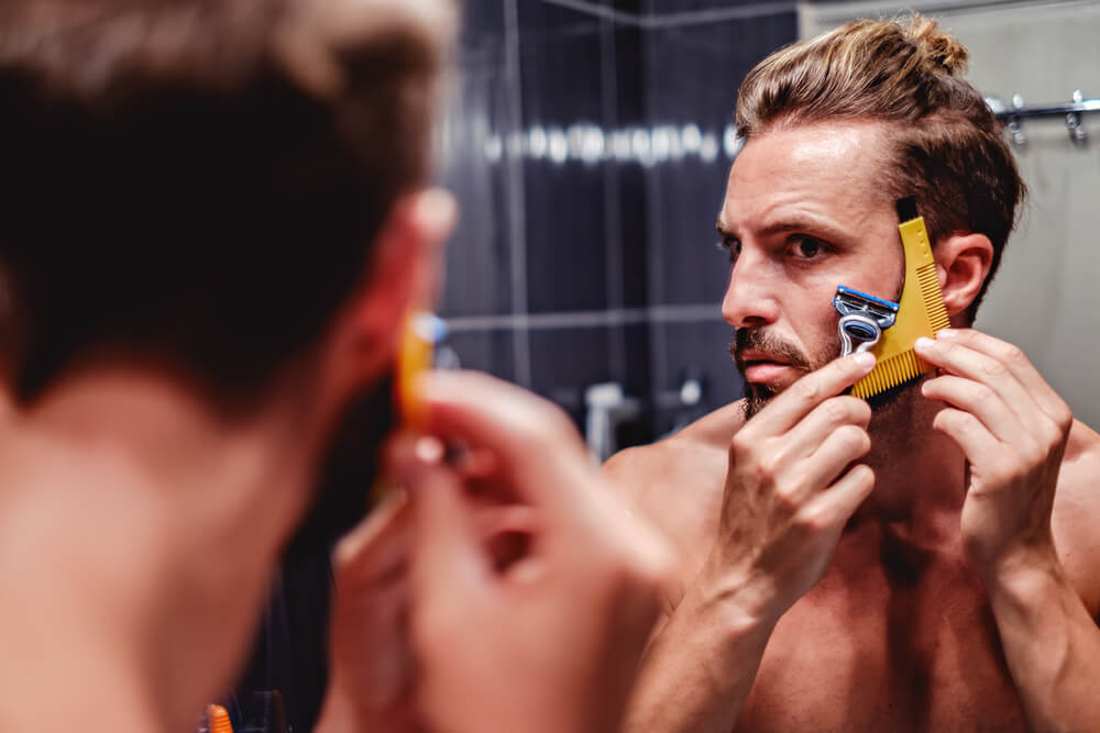 Man shaving his beard in the bathroom 