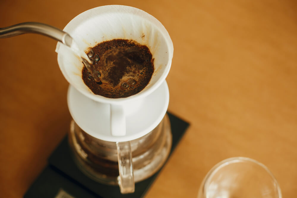 Pouring hot water from steel kettle in filter with ground coffee - Ground Coffee To Water Ratio