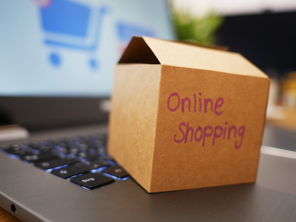 A box labeled with online shopping placed on top of a laptop keyboard.