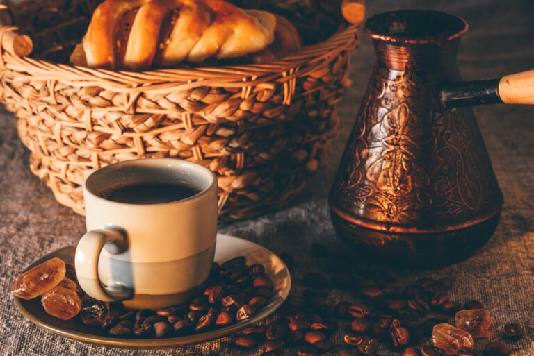Best coffee for turkish coffee. A cup of turkish coffee on a saucer with coffee beans, a basket with bread and a coffee pot