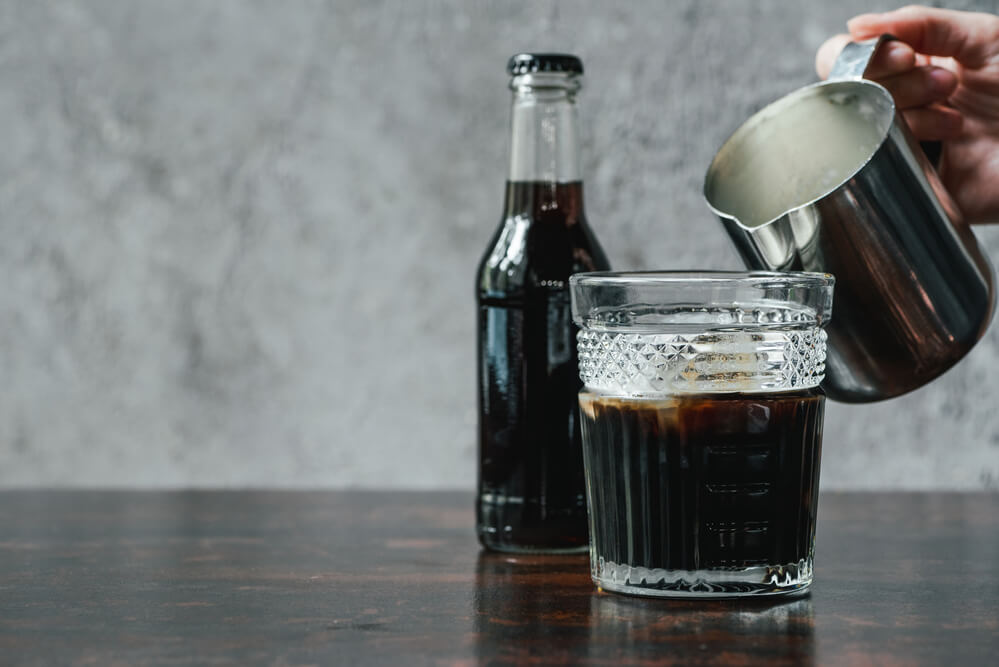 milk poured over a hot brewed coffee