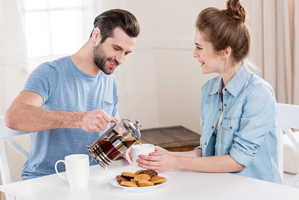 a man pouring down a tea to the woman