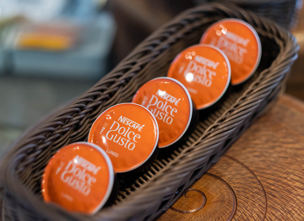 five dolce gusto pods in a wooden basket