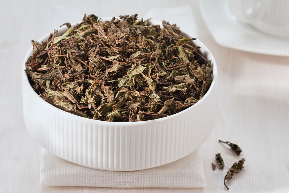 Dried spearmint leaves on a white bowl