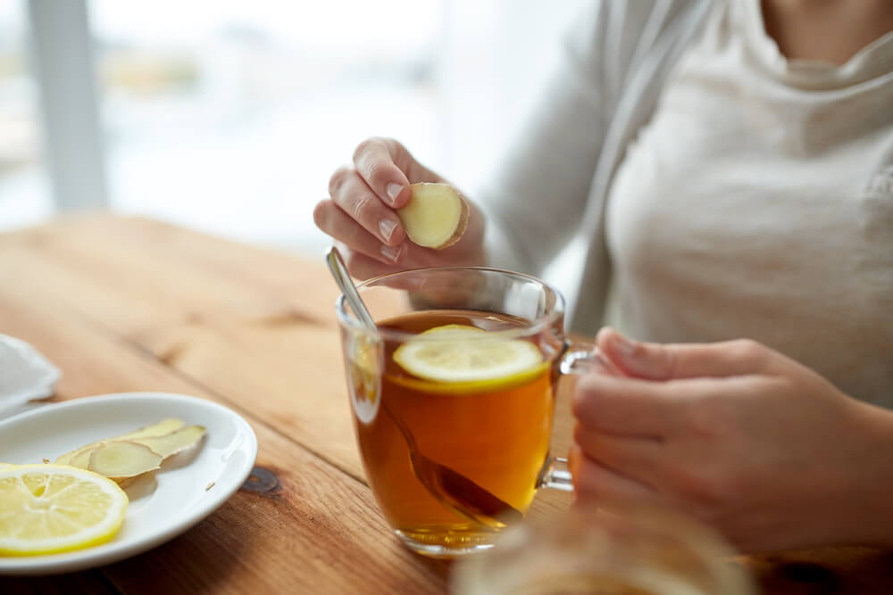 woman putting the peeled ginger in her tea