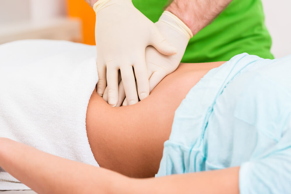 a doctor pressing the abdomen of his patient