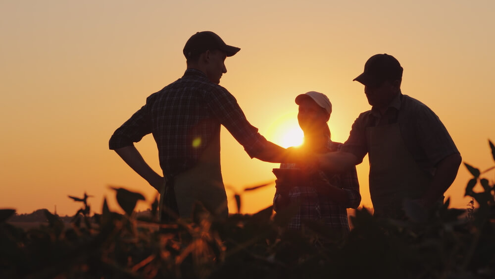 A group of farmers in the field, shaking hands