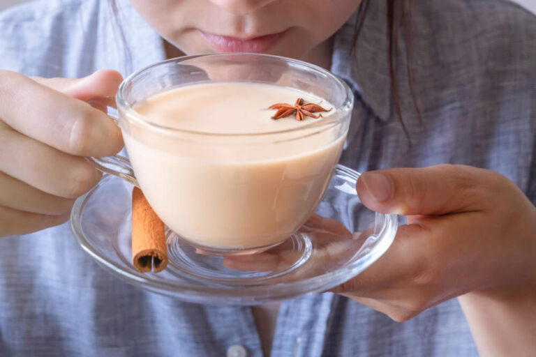 Young caucasian woman enjoing a cup of masala chai tea - What is masala tea