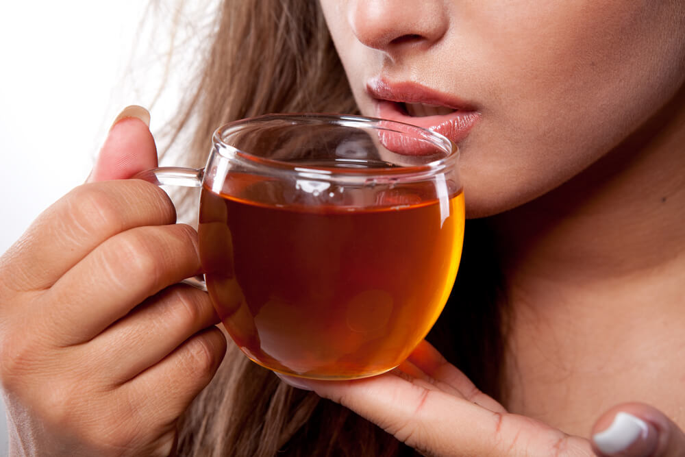 a woman holding her tea both her hands 