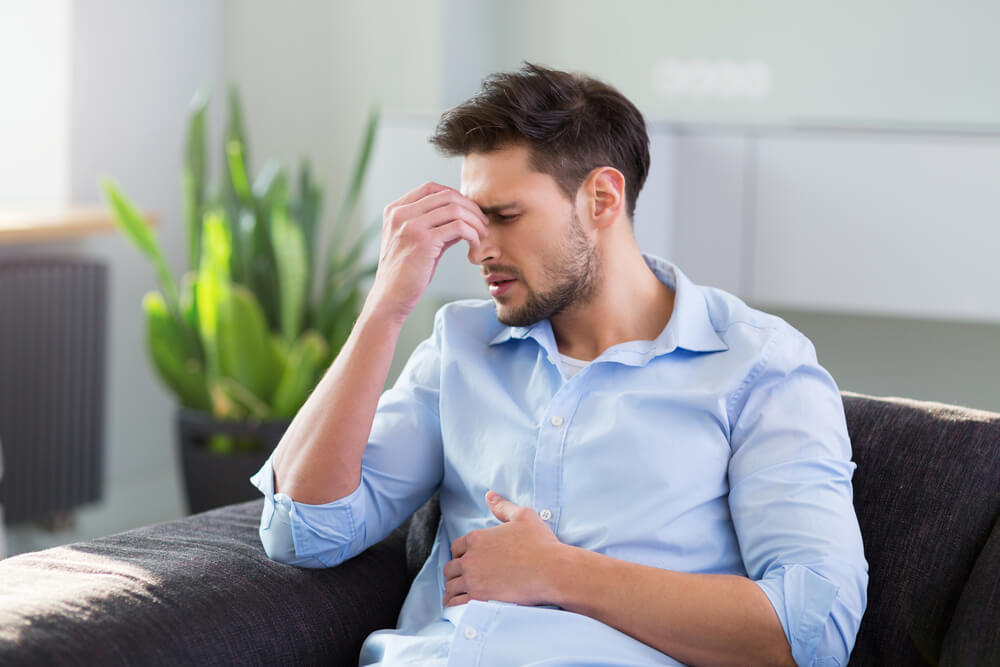 a man having stomach cramps and headache