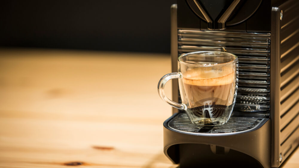 a Nespresso pixie coffee machine with a mug