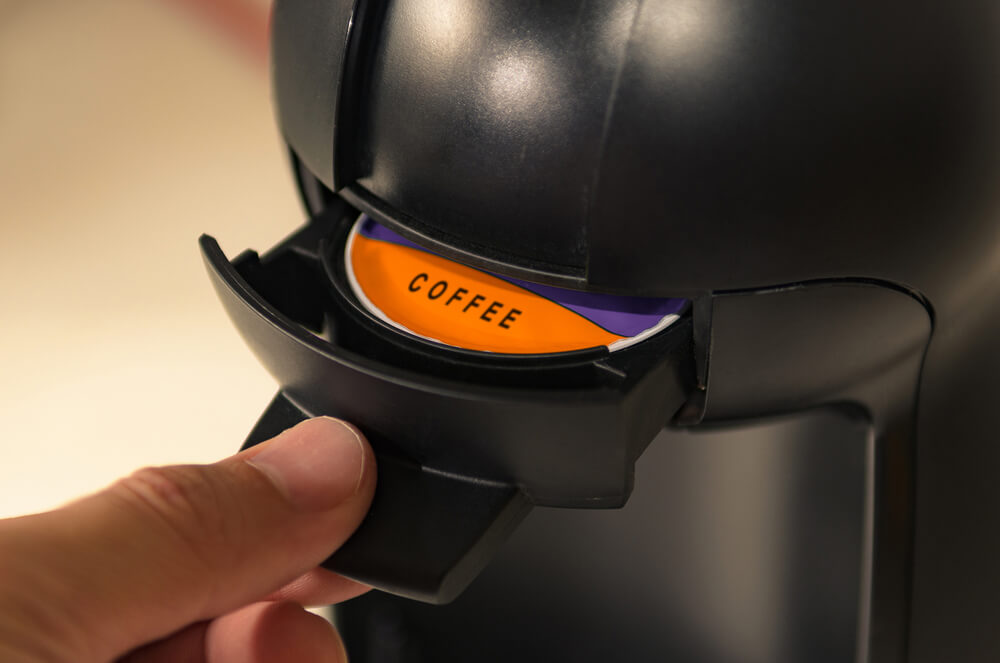 a hand pressing the drawing of the espresso machine