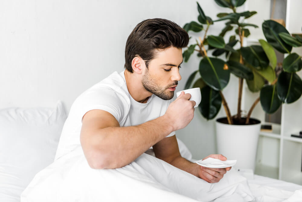 a man trying to sip his cup of tea
