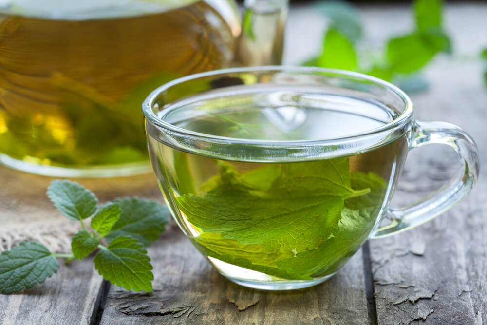 a close up view of green tea on a wooden table