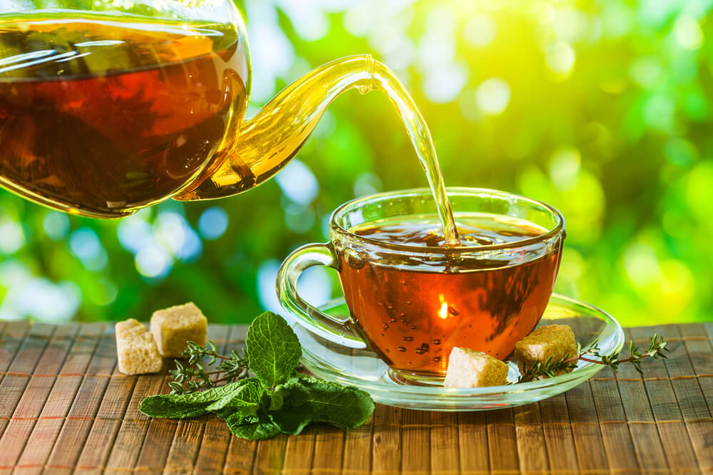 a tea being poured down into a mug