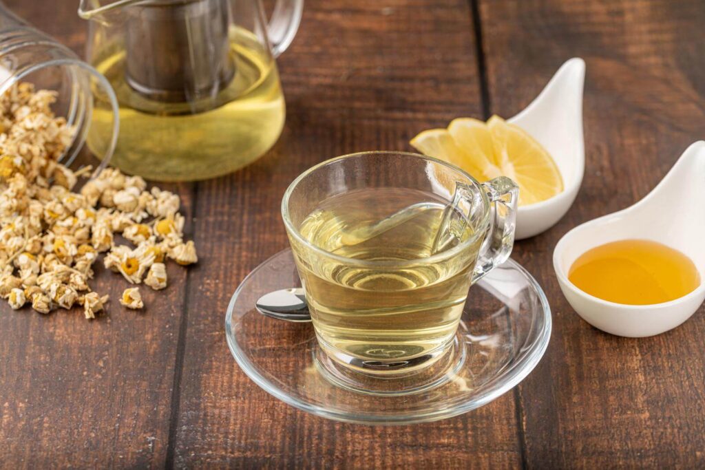 Relaxing chamomile tea in a glass cup with lemon slices and honey