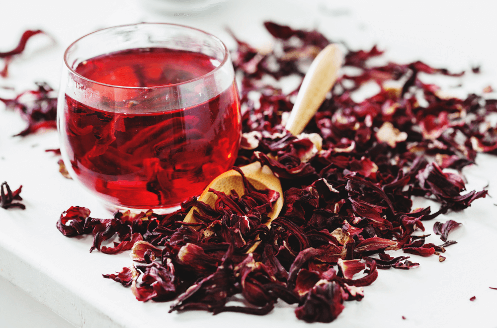 Hot hibiscus tea in a glass cup and spoon closeup on the table