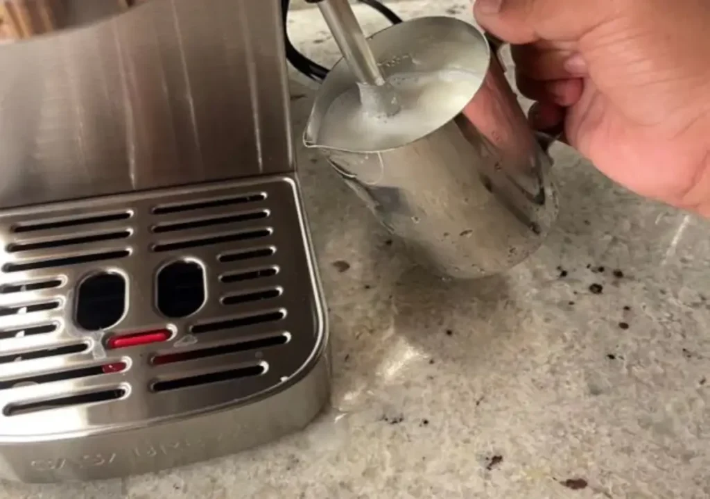A hand froth a milk