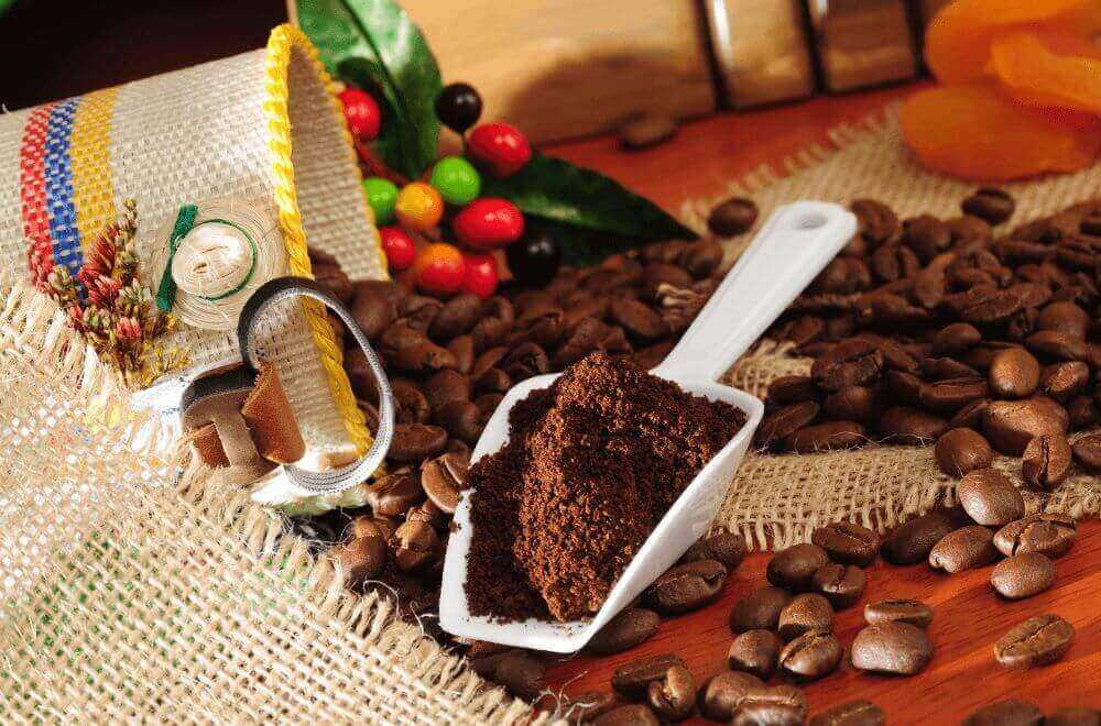 Colombian coffee beans and ground coffee on a wooden table