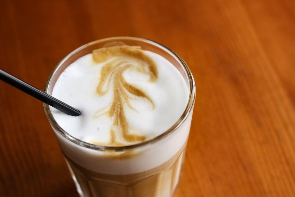 Latte coffee in a glass on a wooden table