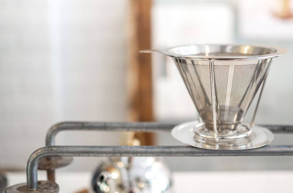 Stainless steel coffee filter reusable funnel coffee dripper, V-type filter cup with copy space.