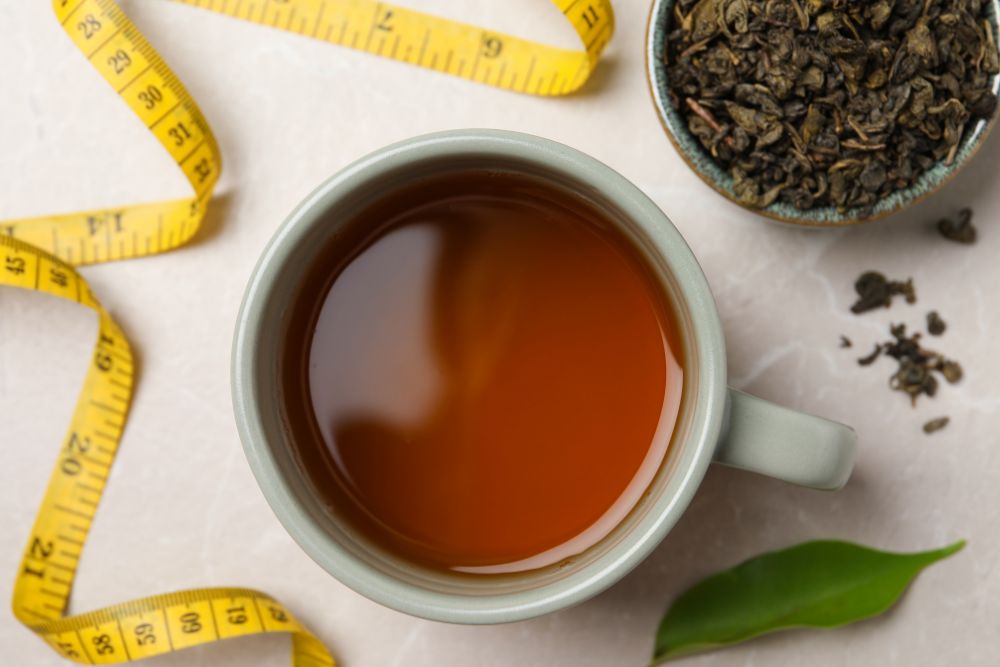 Flat lay composition with herbal diet tea and measuring tape
