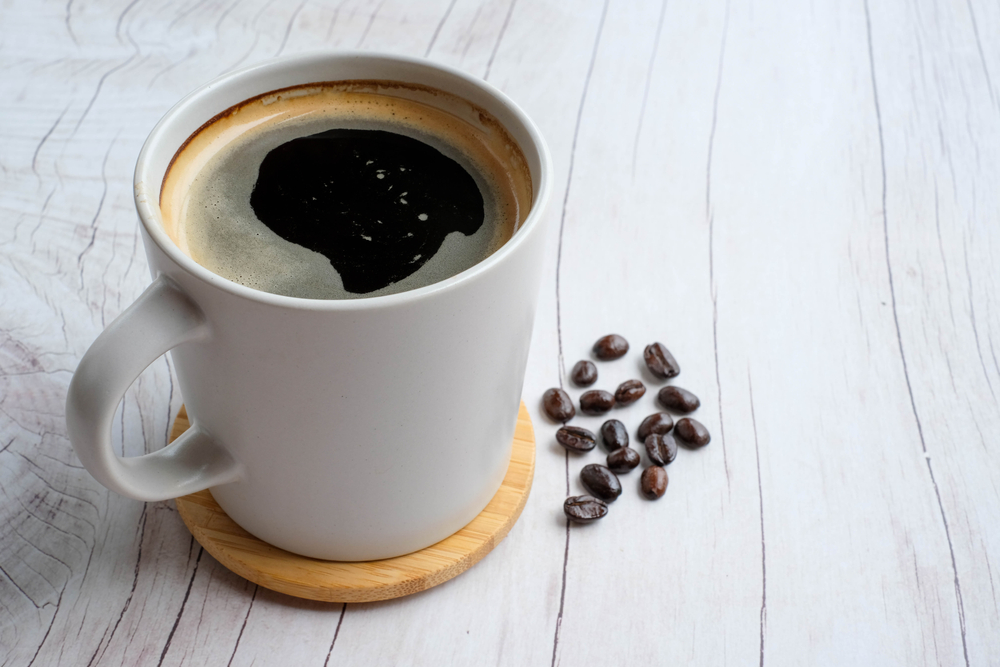 americano with Coffee beans on wood texture background