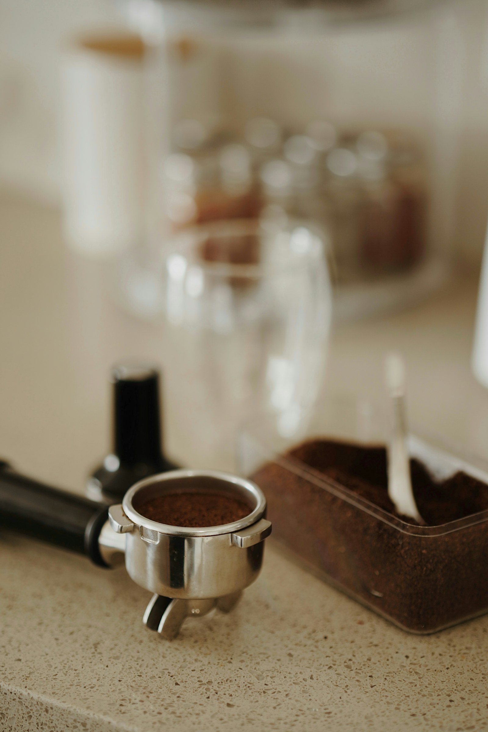 Ground coffee in a portafilter on a kitchen counter; illustrative espresso preparation scene.