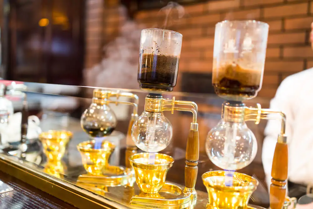siphon coffee brewer at a coffee bar - how to brew coffee with a siphon
