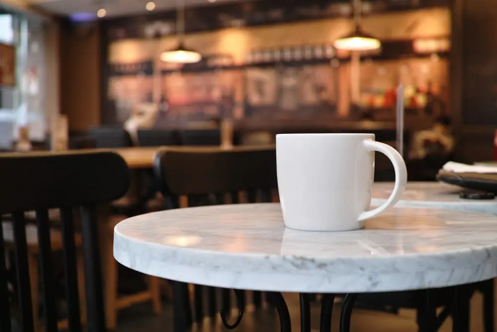 A cup of coffee on a table in a coffee shop.