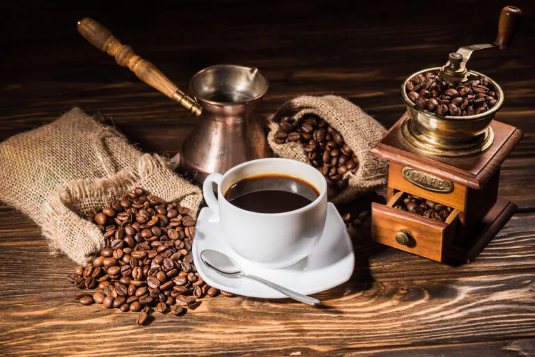 cup of coffee with coffee beans and a coffee pot