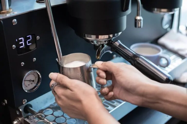 barista-holding-pitcher-full-of-frothed-milk