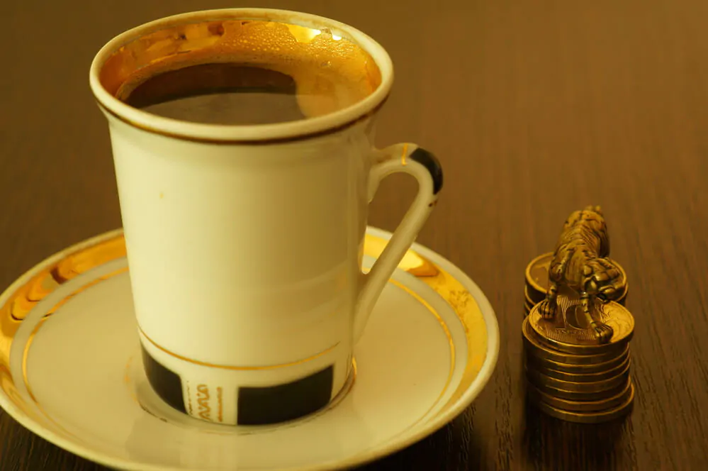 A cup of coffee and a tiger figure on the table