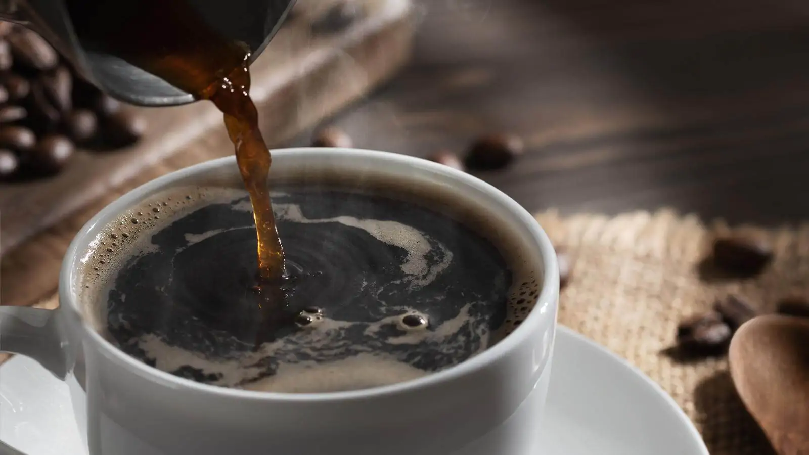 Pouring freshly brewed hot cezve coffee into a white cup - is there any coffee without caffeine