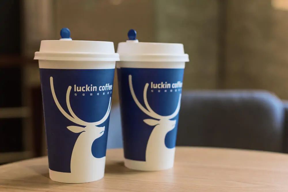 two Luckin coffee cups on a wooden table - how does Luckin coffee work